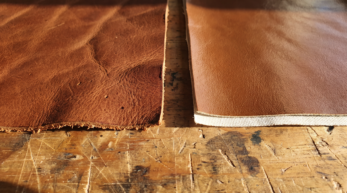 A piece of real leather with a rough cut edge beside a smooth faux leather sheet with a fabric backing showing at its edge