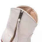 Close-up of the back zipper and tan lining on The Trinity boot in white leather