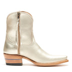 Side profile of a single Trinity ankle boot in champagne leather with its zipper pull