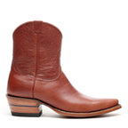 Side profile of a single Trinity boot in cognac leather set against a white backdrop