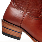 Close-up of the stacked heel on The Trinity boot in cognac leather with its blue stripe