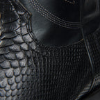 Angled close-up of the black leather-to-python seam on The 6th Street shaft.